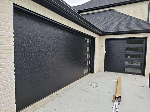Textured black contemporary garage door with a vertical glass panel column