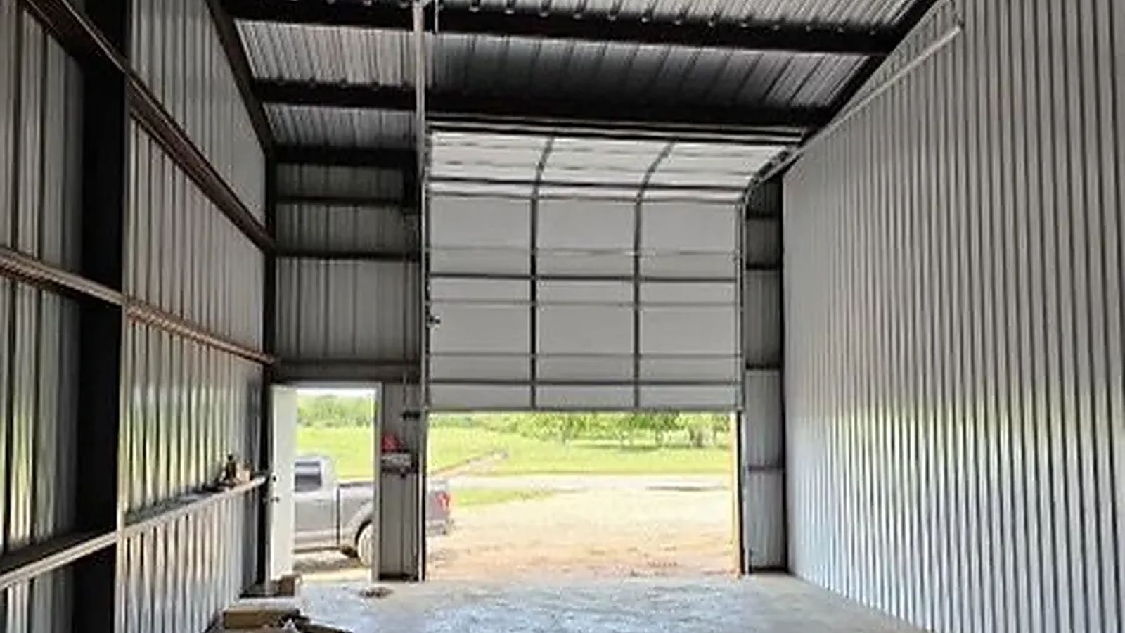 Garage door tracks and overhead door hardware seen from inside a shop building