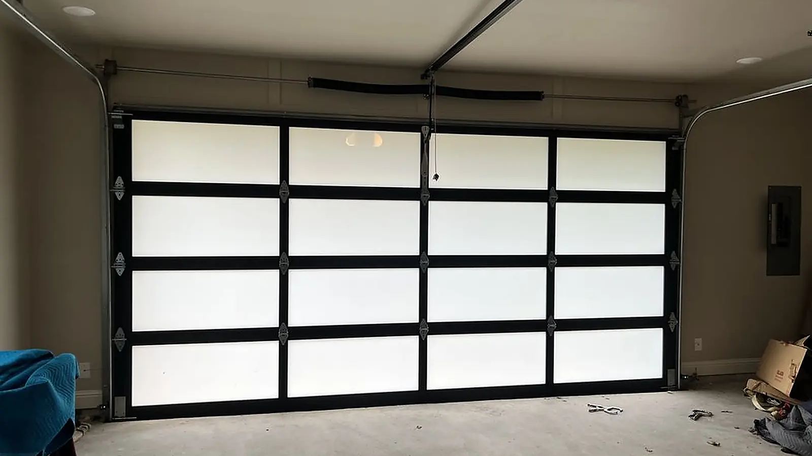 New ceiling-mounted garage door opener rail installed above a frosted glass garage door